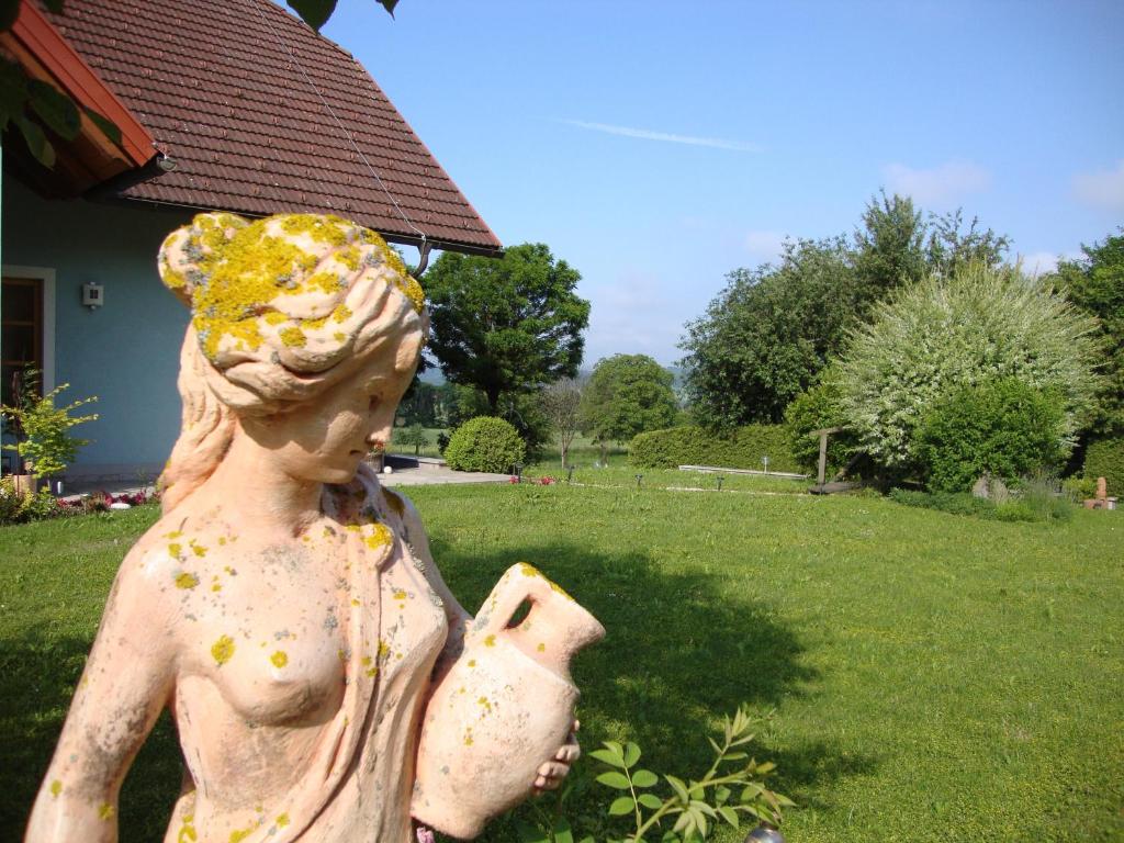 una estatua de una chica sosteniendo una olla en un patio en Casa Anna, en Bad Gleichenberg