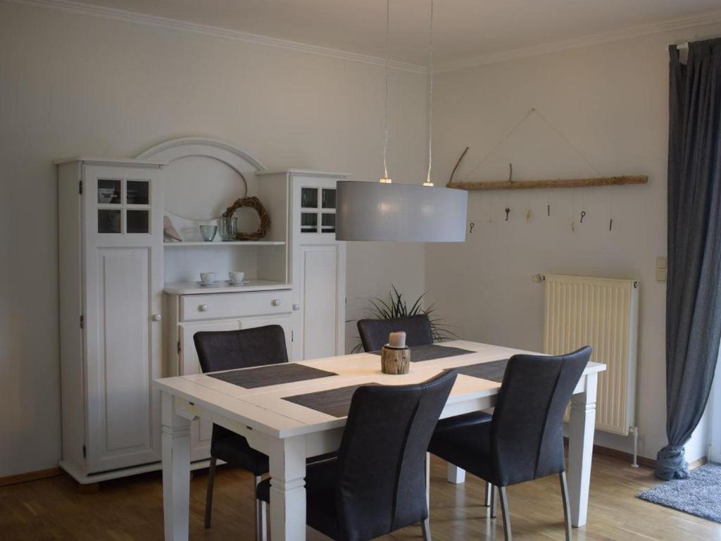 a kitchen with a white table and chairs at Ferienhaus Strandgeflüster in Garding