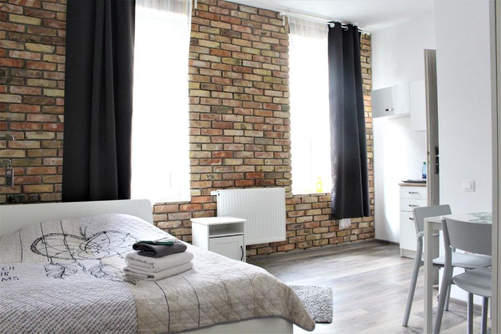 a bedroom with a bed and a brick wall at Stay99 Apart in Poznań