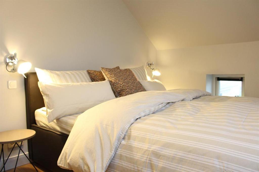 a bedroom with a bed with white sheets and pillows at Ferienhäuser SPO in Sankt Peter-Ording