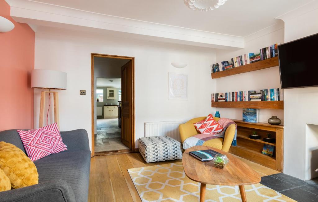 een woonkamer met een bank en een tafel bij The Madras Cottage - Bright 3BDR Home with Garden in Cambridge