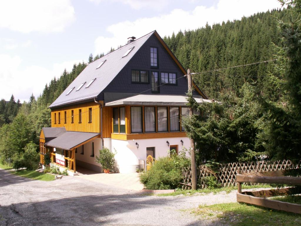una gran casa blanca y amarilla con árboles en Ferienwohnung Sternkopf en Breitenbrunn