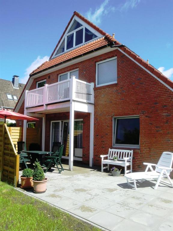 a brick house with a deck and a patio at Ferienwohnung Stadtfelder in Böhl