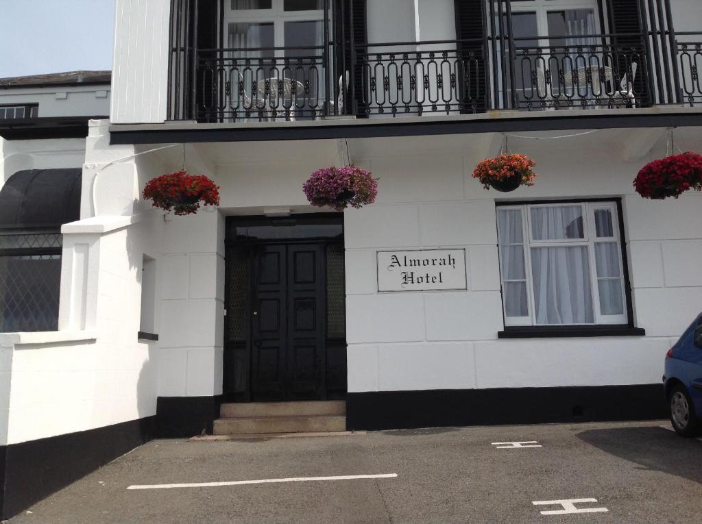 a white house with a blue door and windows at Almorah Hotel in Saint Helier Jersey