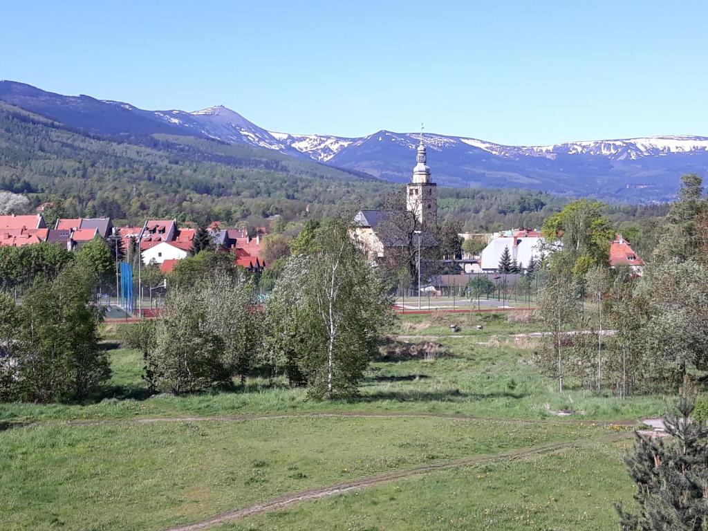 a small town with a clock tower in a field at Apartament Pod Śnieżką in Kowary