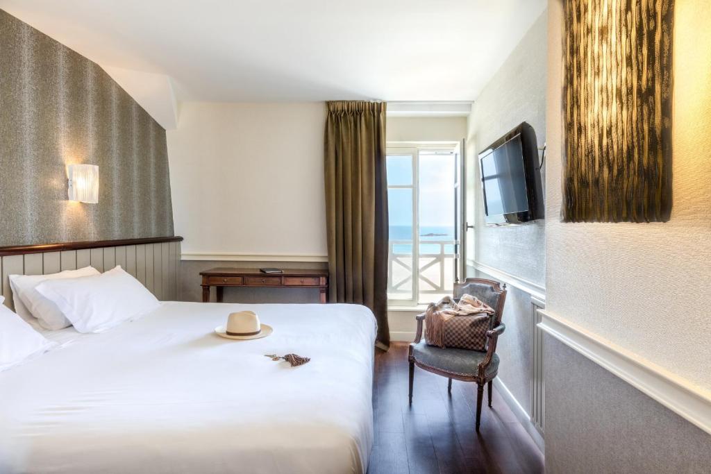 a hotel room with a bed and a television at Hôtel Le Beaufort in Saint Malo