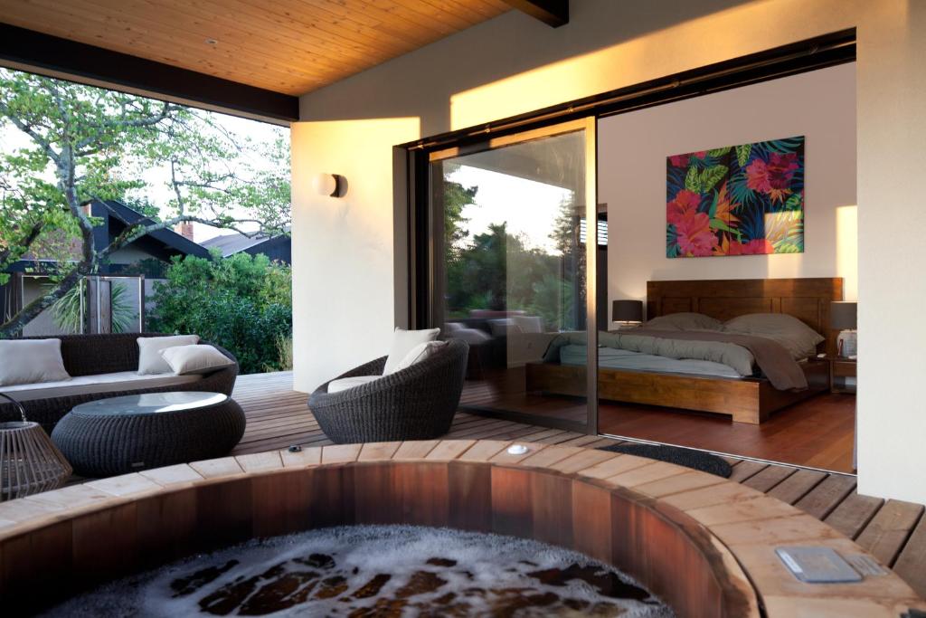 un salon avec un bain à remous et une chambre dans l'établissement Villa Margaux, à Fargues-Saint-Hilaire