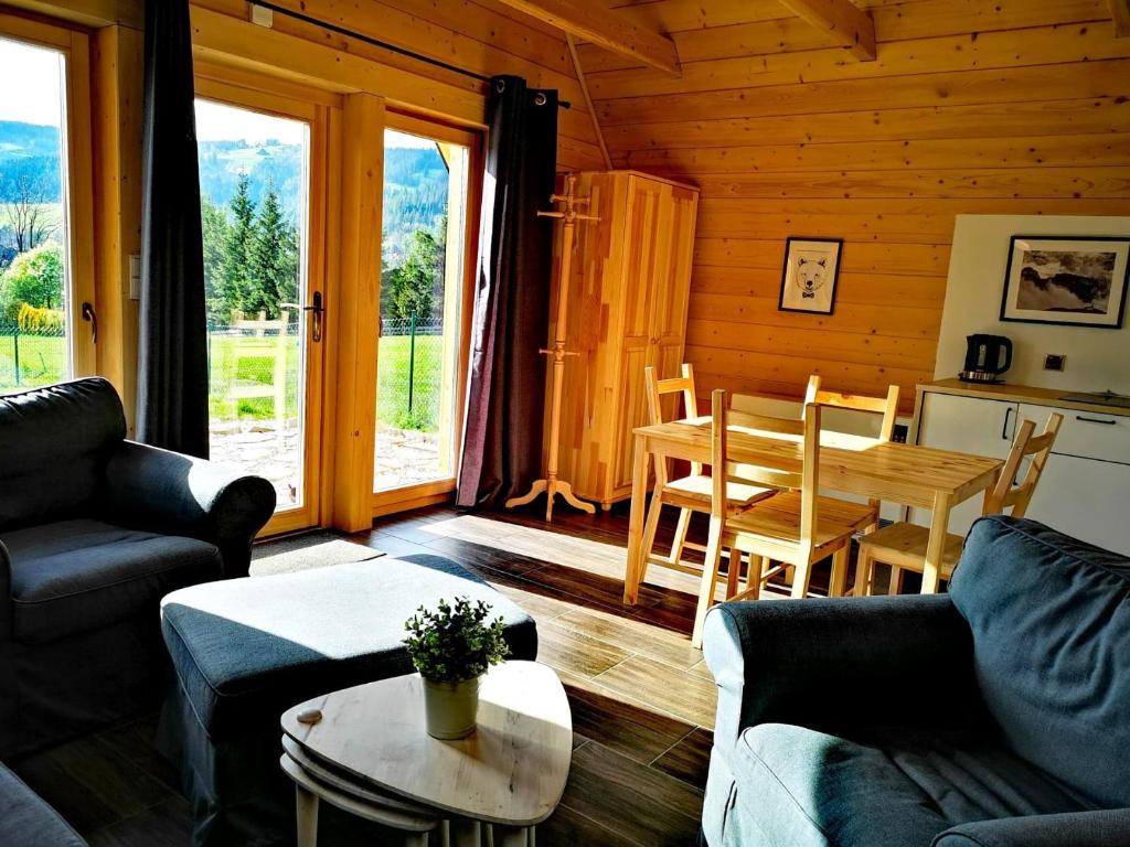 a living room with couches and a table and a dining room at Górski Szałas in Zakopane