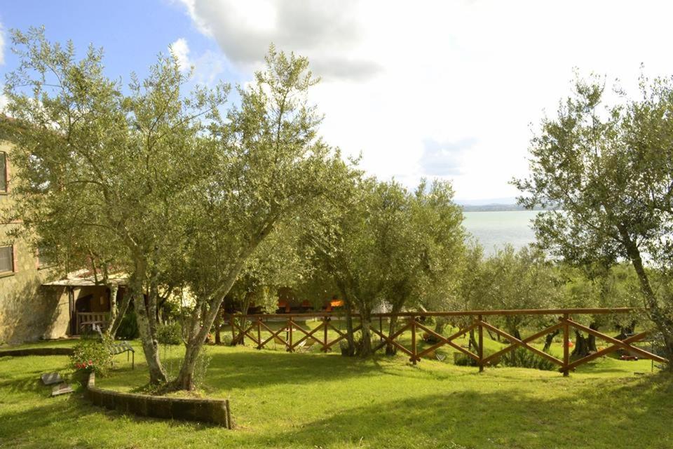 um jardim com árvores e uma cerca de madeira em Fattoria Il Poggio em San Feliciano