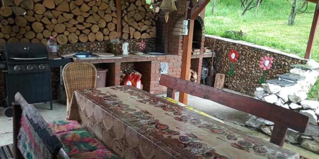 a room with a bench and a stove with logs at Pensiunea Dorel Codoban in Lazuri