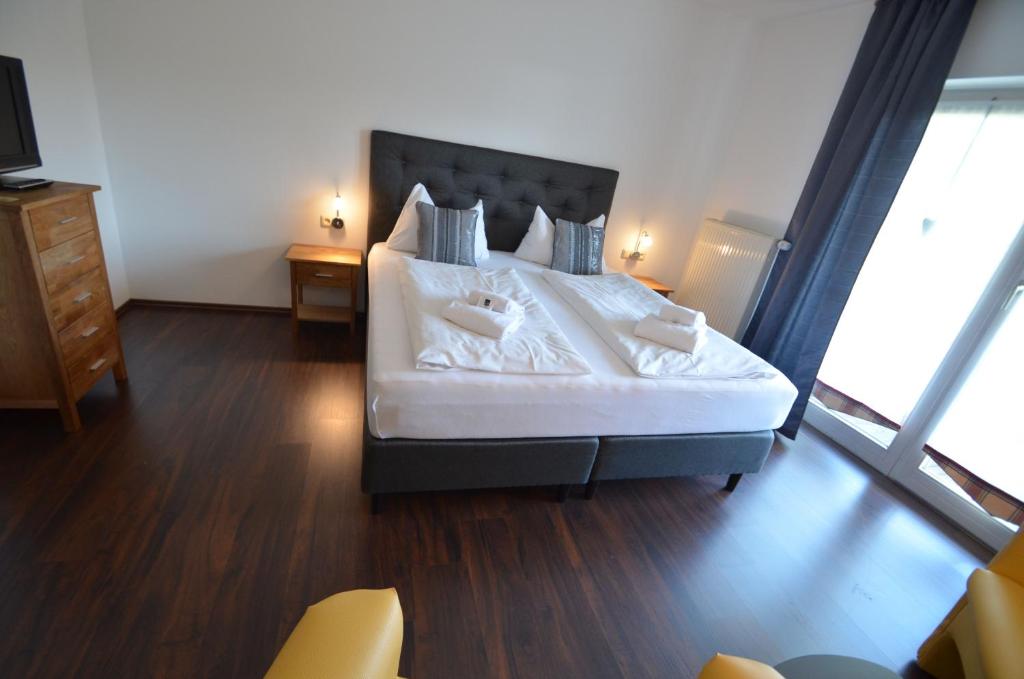 a bedroom with a large bed with a large window at Landhotel Christopherhof in Grafenwiesen