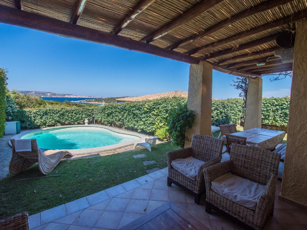 a patio with chairs and a swimming pool at Villa Fiore con Piscina e Vista Mare in Palau