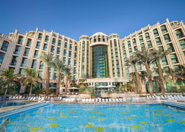 a large building with a large swimming pool in front of it at level of 5 star on the beach in Eilat