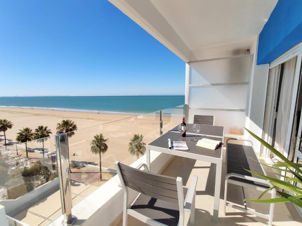 balcón con mesa y sillas y playa en Apartamento Sea Views Rota, en Rota