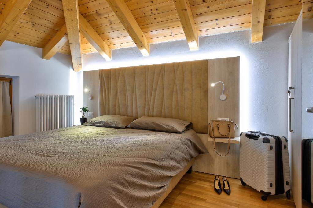- une chambre avec un grand lit et un plafond en bois dans l'établissement Concilium, à Trente