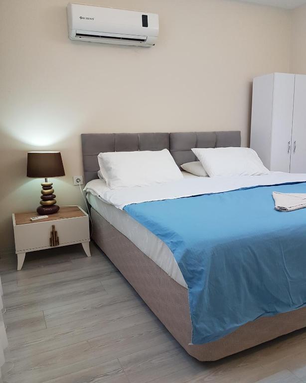 a bedroom with a large bed and a night stand at Yeşilyurt Residence in İzmir