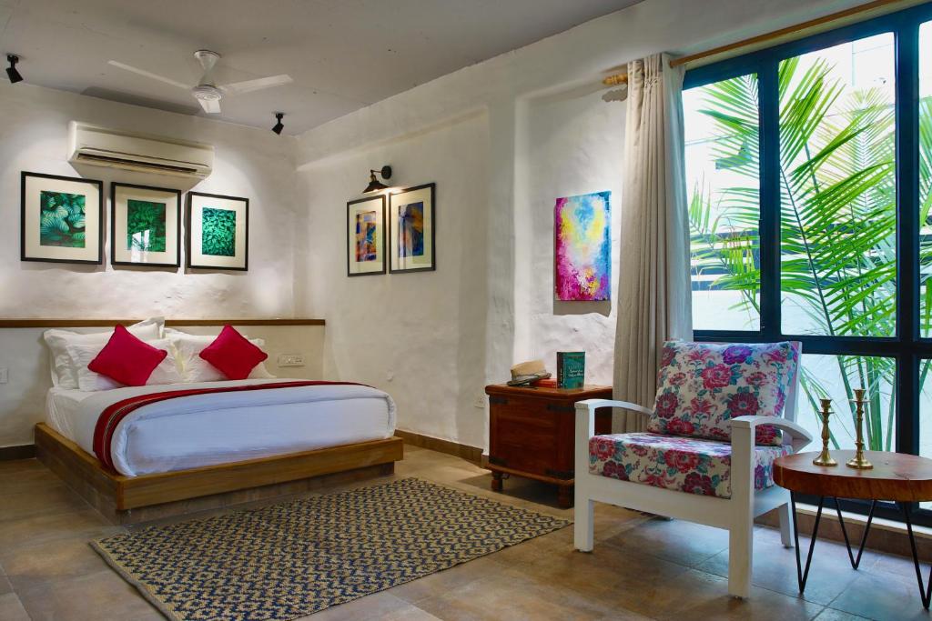 a bedroom with a bed and a chair and a window at Hotel North House - Best Boutique Hotel in Haldwani in Haldwāni