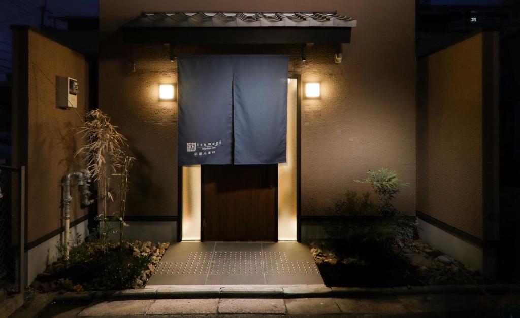 a front door of a building with a blue banner on it at Kanade Kyoto-Hachijoguchi in Kyoto
