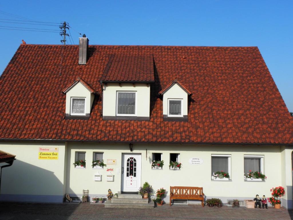 ein weißes Haus mit rotem Dach in der Unterkunft Pension Gästeparadies in Kleinkötz