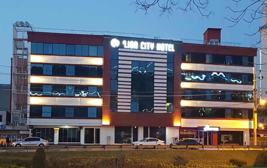 un edificio con coches estacionados frente a él en Lioncity Hotel, en Bursa