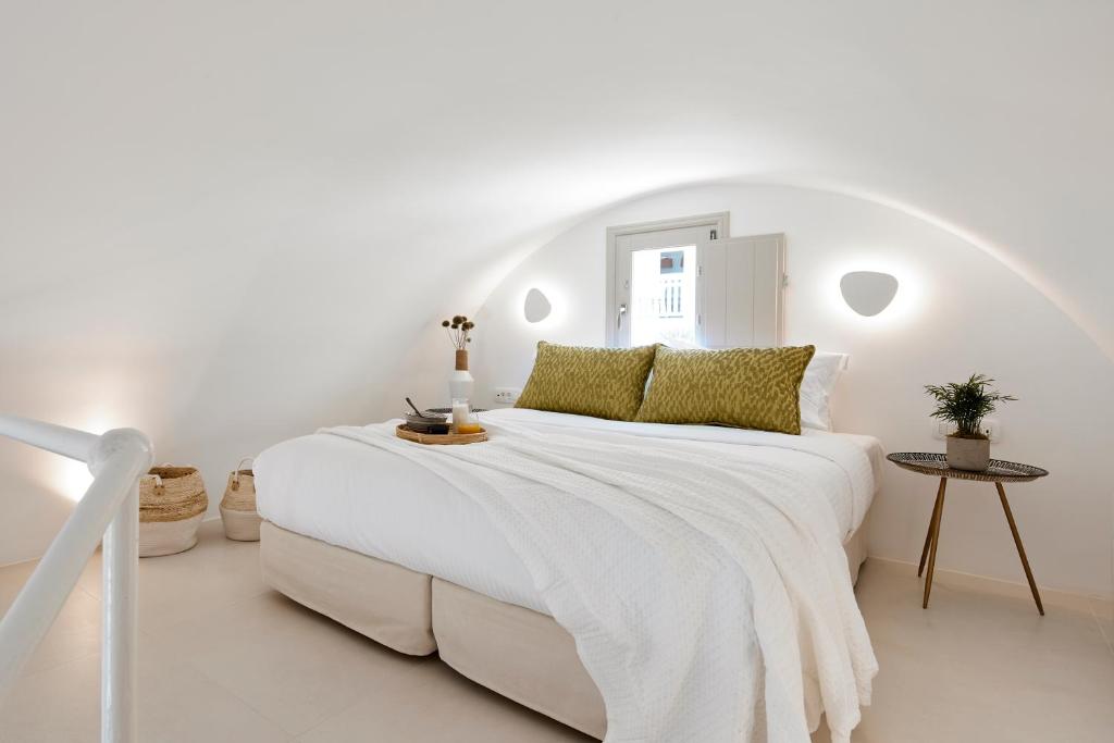 biała sypialnia z dużym białym łóżkiem w pokoju w obiekcie Star Infinity Suites w mieście Pirgos