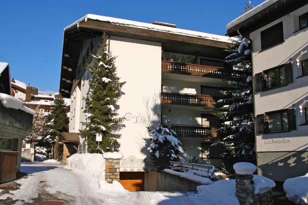 a building with a christmas tree in the snow at Monami Apartments Klosters, Apt. Casa Selva Nr 10 in Klosters