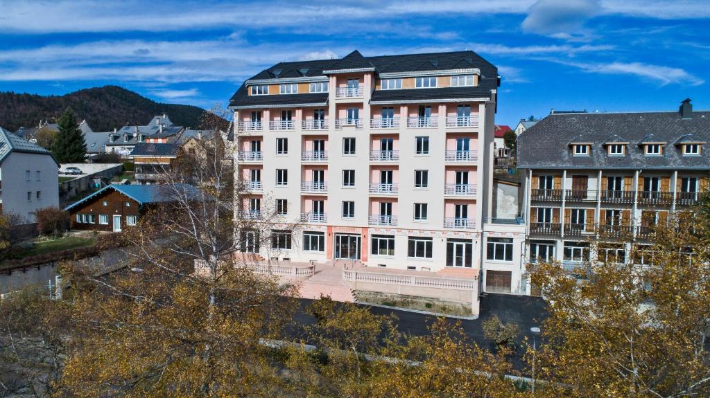 un gran edificio blanco en una ciudad con edificios en RESIDENCE LE SPLENDID, en Villard-de-Lans