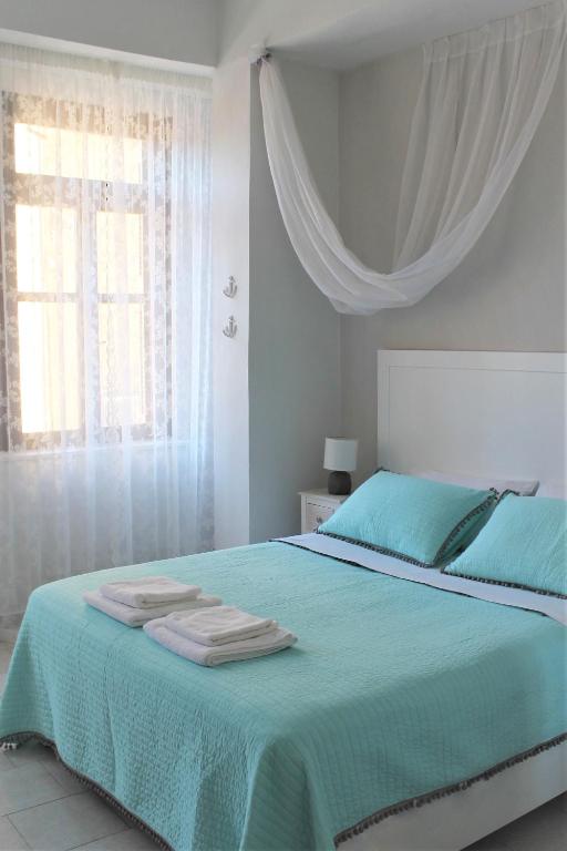 a bedroom with a green bed with towels on it at Dali Rooms in Chania