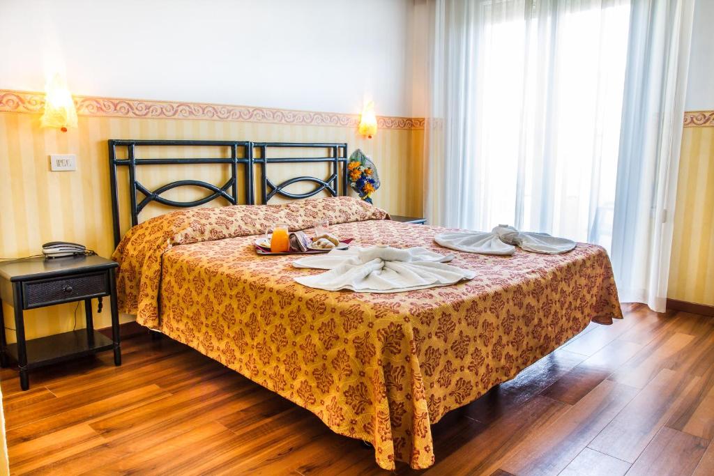 a bedroom with a bed with a tray of food on it at Hotel Consul - Family Hotel in Riccione