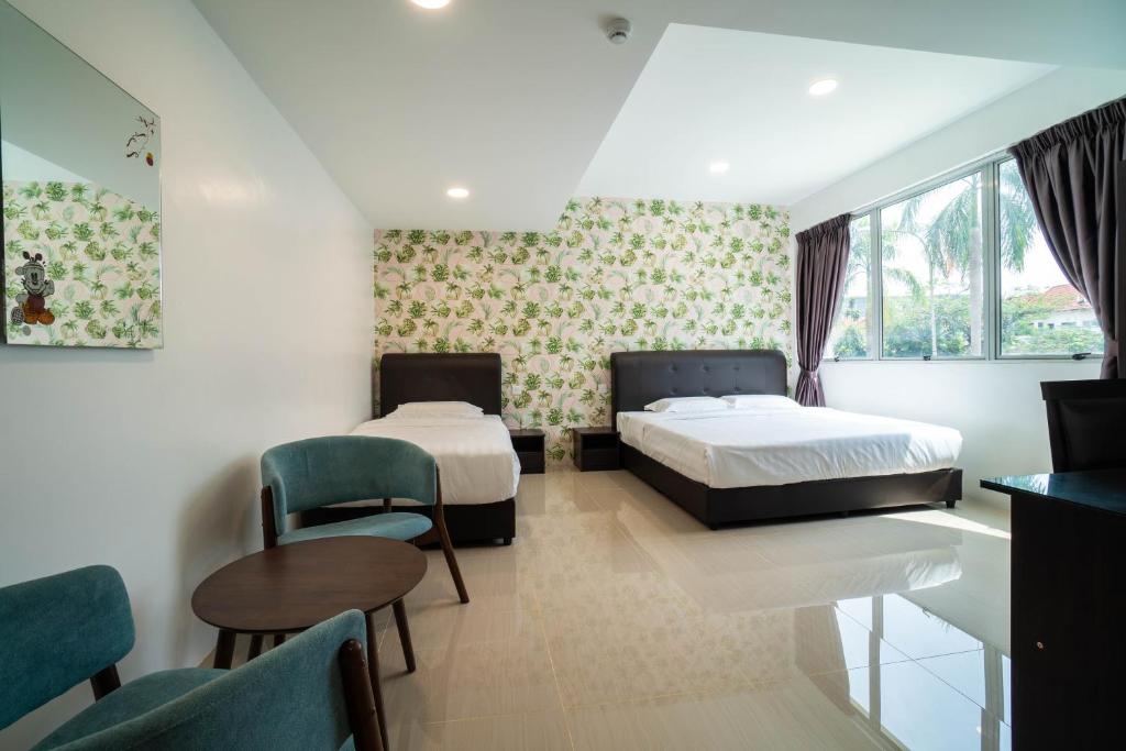 Crystal Garden Hotel (Tasik Selatan) في كوالالمبور: غرفة نوم بسريرين وطاولة وكراسي