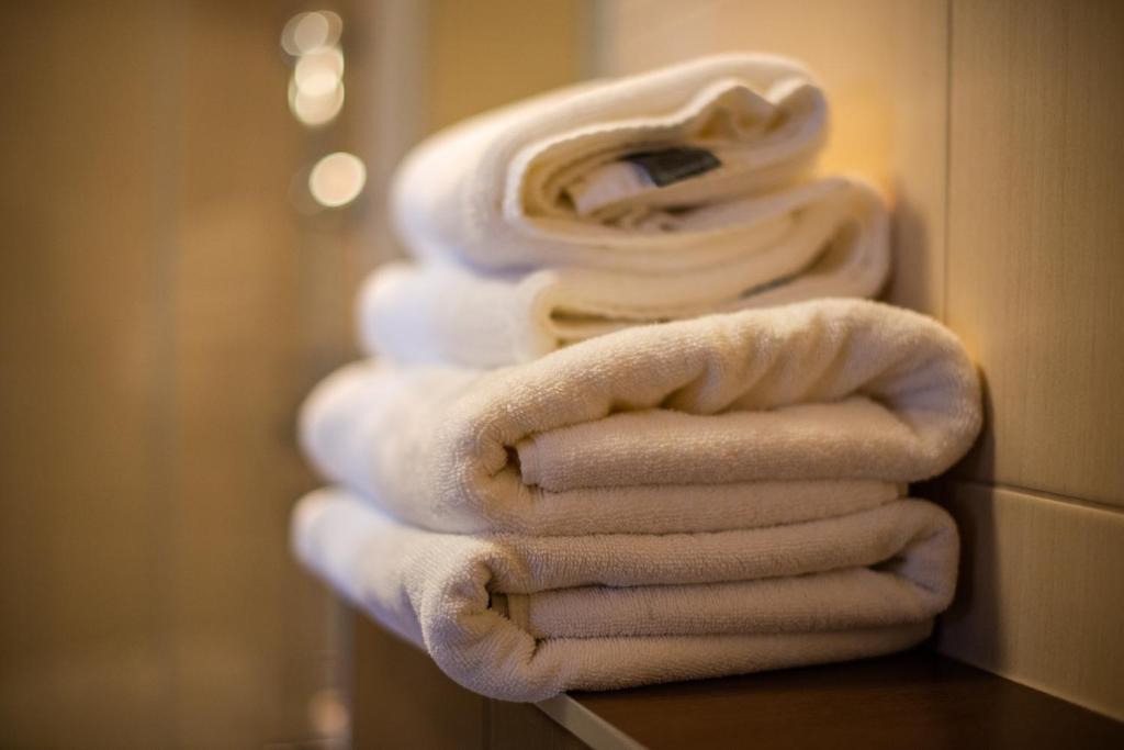 a stack of white towels sitting on a counter in a bathroom at Apartamenty Stella Baltic in Świnoujście