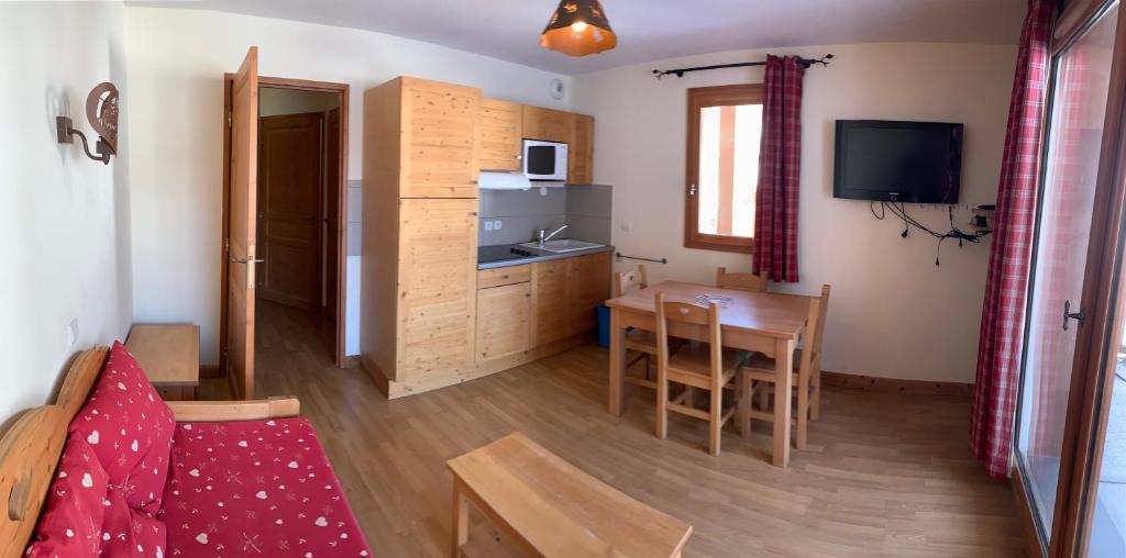een woonkamer met een keuken en een eetkamer bij Boost Your Immo Chalet des Rennes 83 in Vars