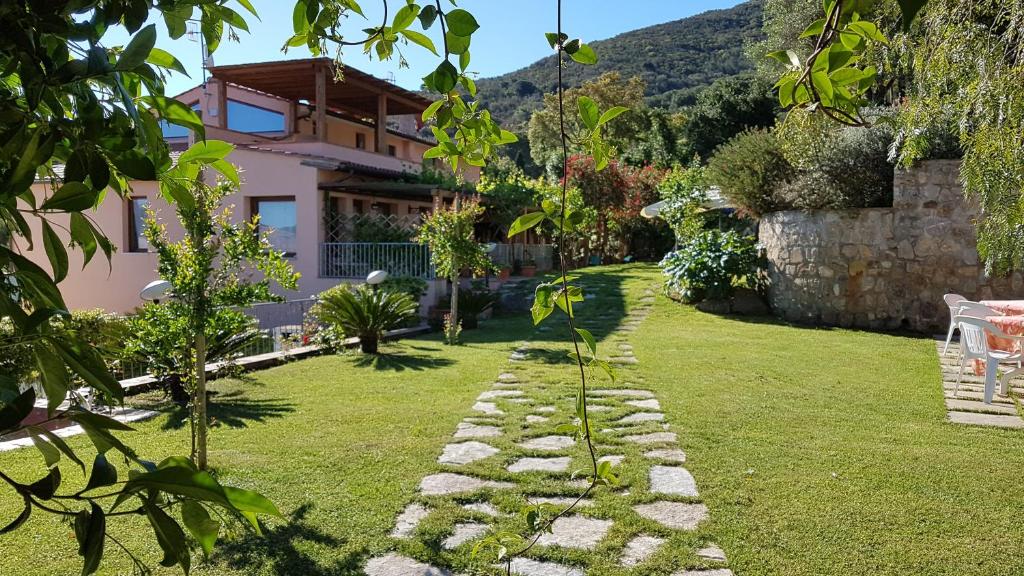 a garden with a stone path in front of a house at Appartamenti Casa Santi in Portoferraio