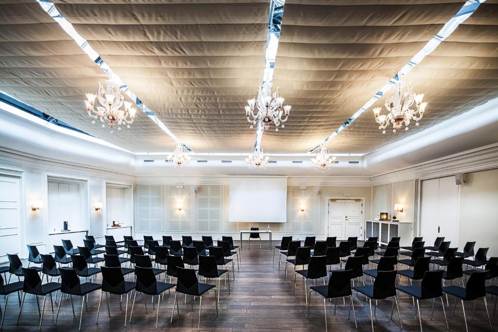 a large room with chairs and a podium in it at First Hotel Grand in Odense