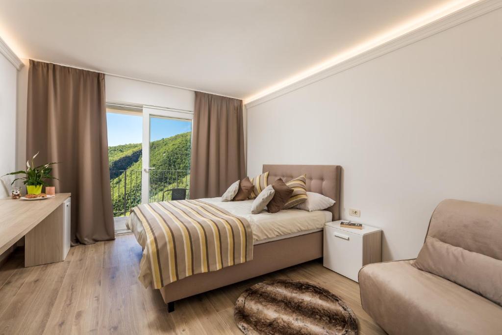 a bedroom with a bed and a large window at Pansion Villa Betina in Lovran