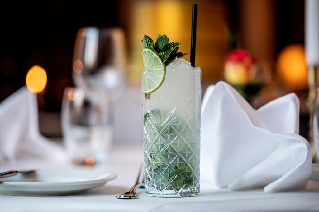 a drink with a lime on a table at First Hotel Grand in Odense