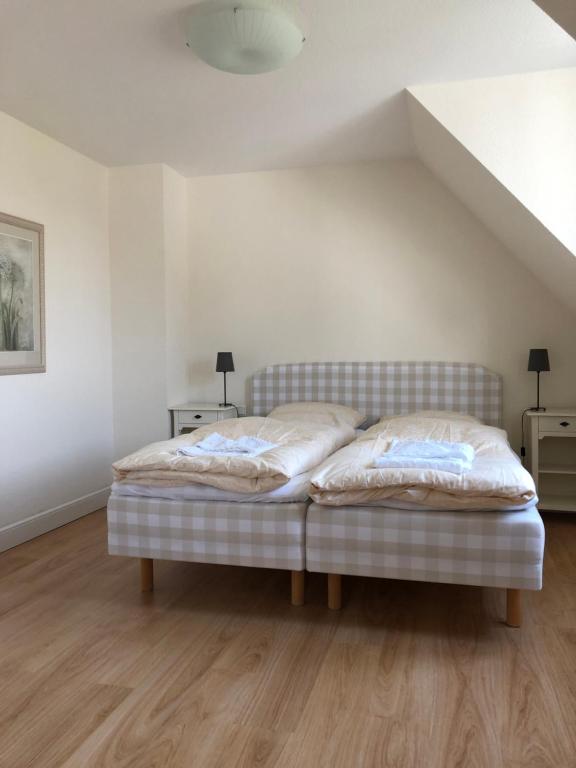 uma cama num quarto branco com duas lâmpadas em Urlaubsglück Familien- & Hunde-Paradies em Rankwitz