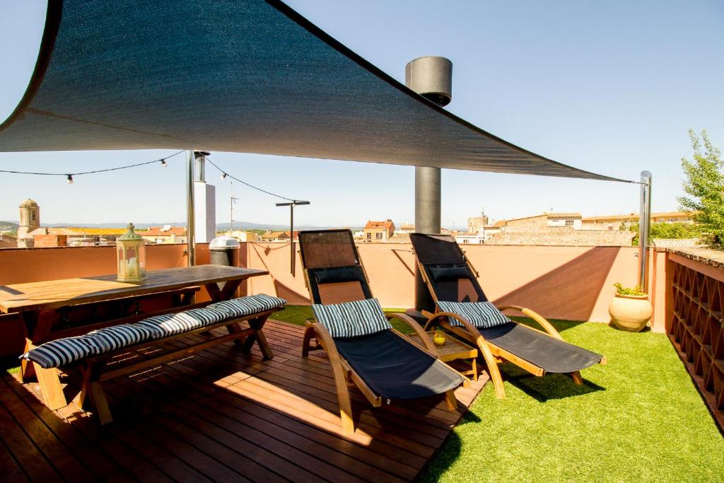 a deck with a table and chairs on a roof at Can Martí Sistachrentals in Torroella de Montgrí