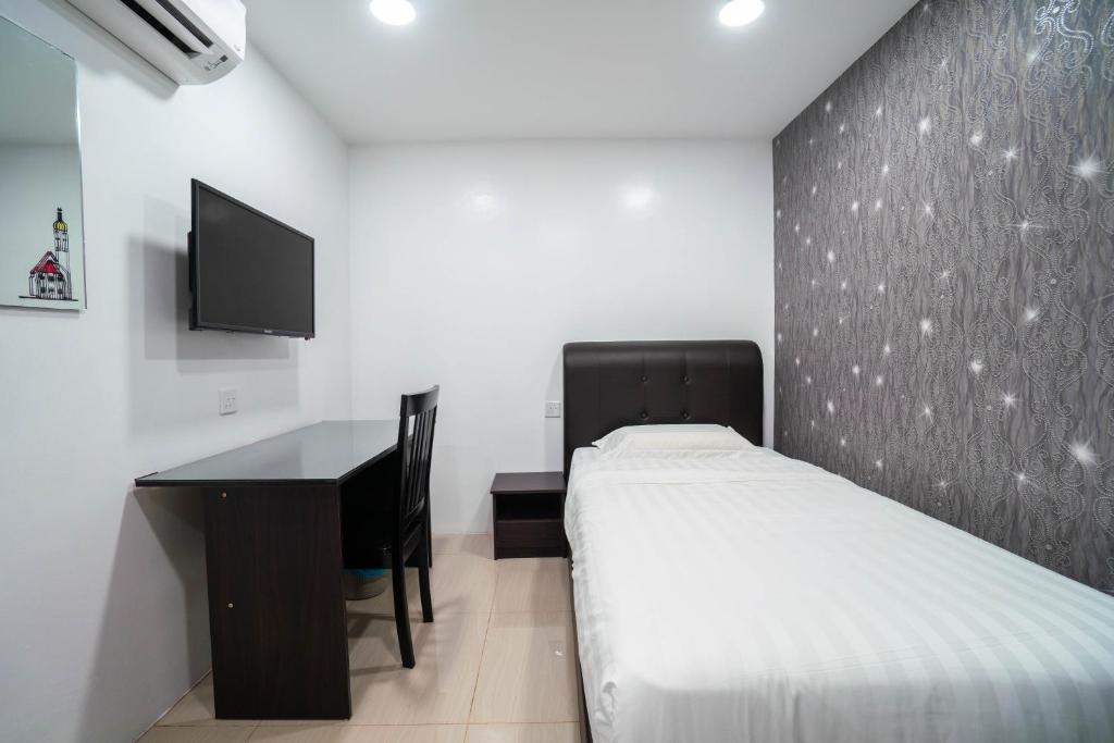 a bedroom with a bed and a desk and a tv at Crystal Garden Hotel (Tasik Selatan) in Kuala Lumpur