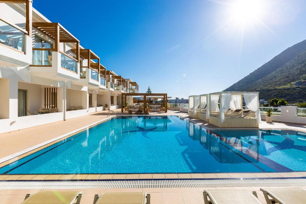 una piscina in un hotel con montagne sullo sfondo di Nostos Beach Boutique Hotel a Balíon