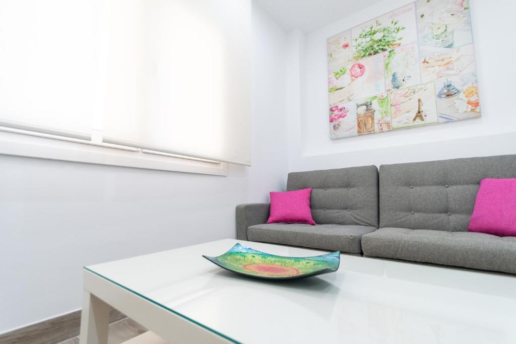 a living room with a table and a couch at Apartamento Amanecer Cadiz in Cádiz