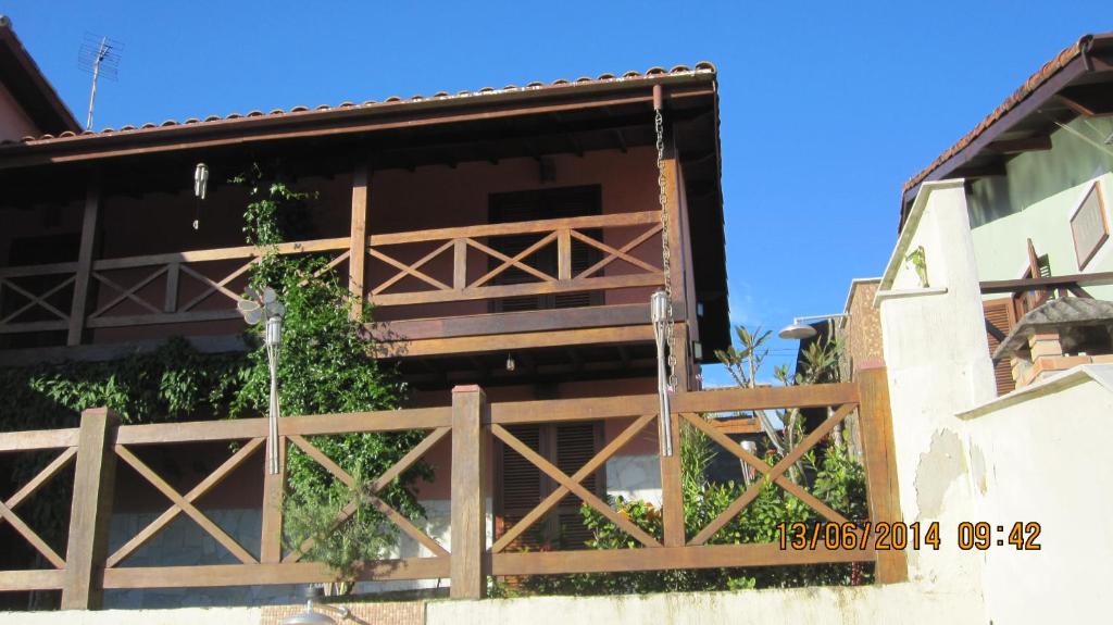 una valla de madera en el lateral de un edificio en Chalés e suite Ilhabela, en Ilhabela