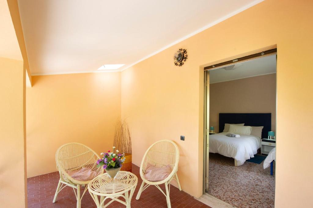 Habitación con 2 sillas, 1 cama y espejo. en Monteleto House.. dove Pace regna, en Gubbio
