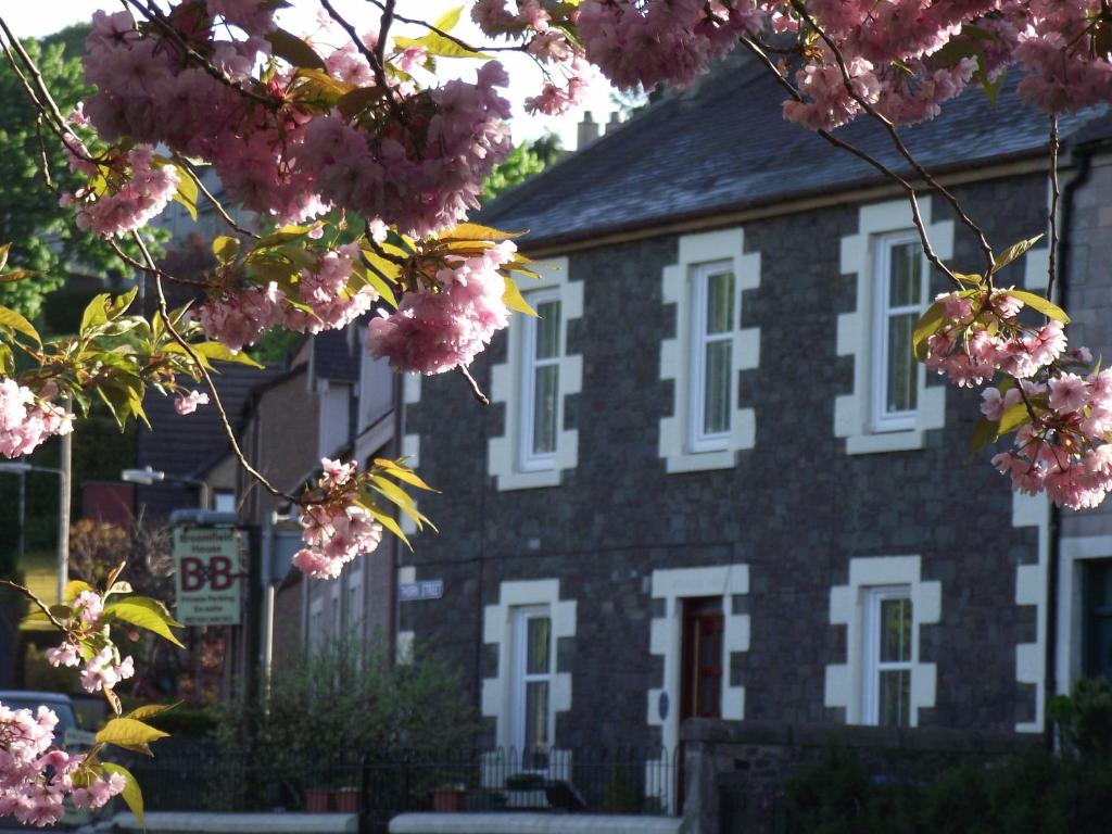 un edificio con un ramo de flores rosas delante de él en Broomfield House Bed and Breakfast en Earlston