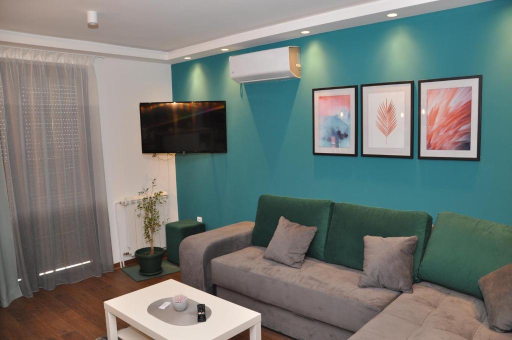 - un salon avec un canapé et une télévision dans l'établissement Lux apartman Čačak, à Čačak