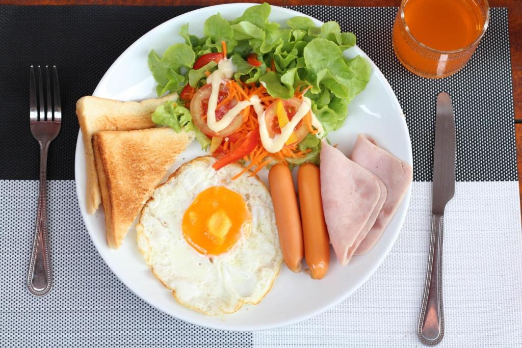 um prato de comida de pequeno-almoço com um ovo e vegetais em Sirikul Mansion em Nai Yang Beach