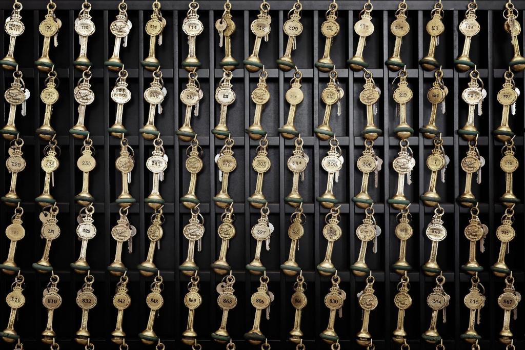 a bunch of gold clocks on a metal wall at First Hotel Grand in Odense