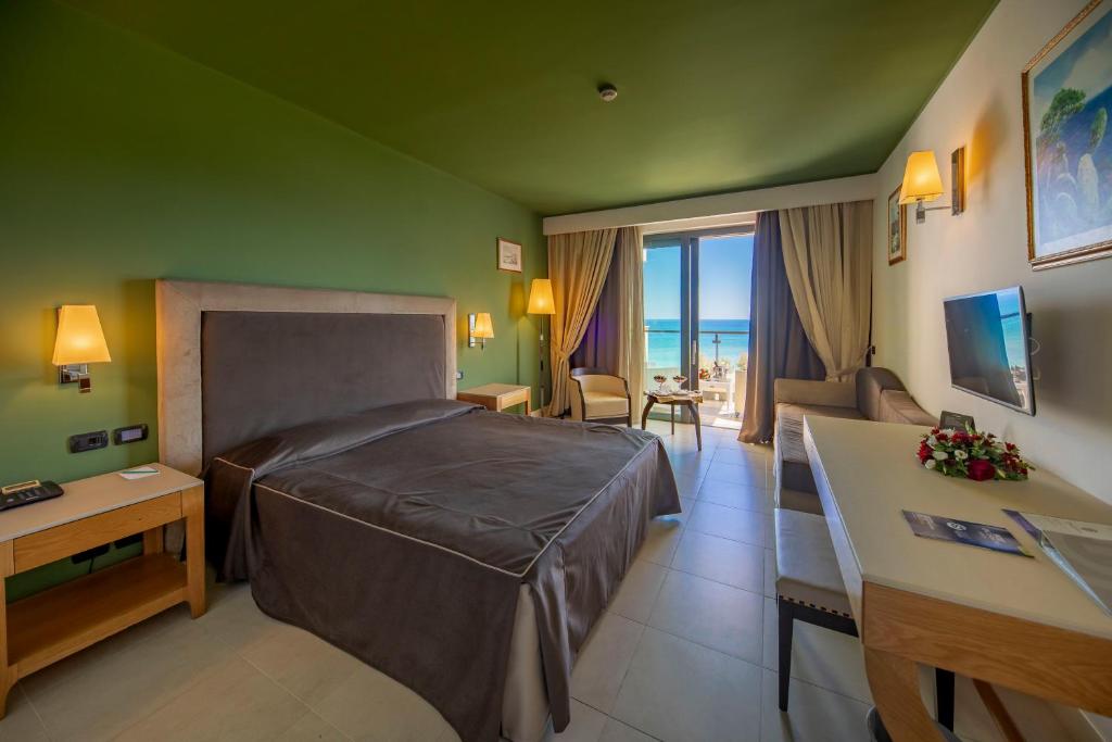 een slaapkamer met een bed en een woonkamer bij Cefalù Sea Palace in Cefalù