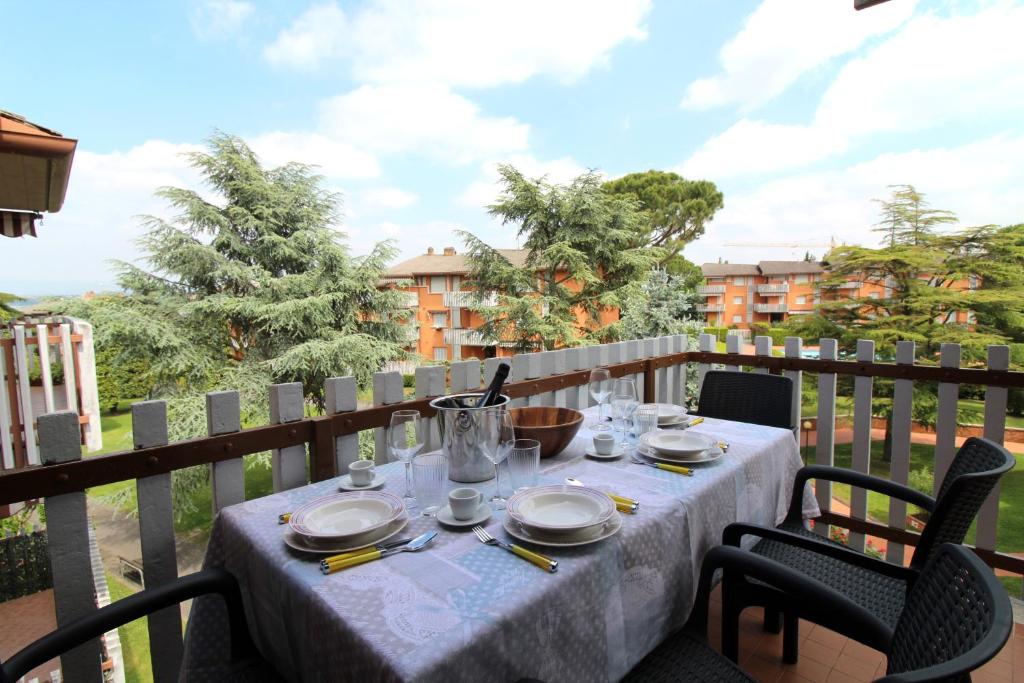 una mesa con platos y utensilios en el balcón en Appartamento Onda Blu, en Peschiera del Garda
