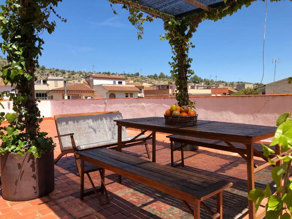 - une table et un banc sur une terrasse avec un bol de fruits dans l'établissement Casa Rural "Casa Maria", à Artana